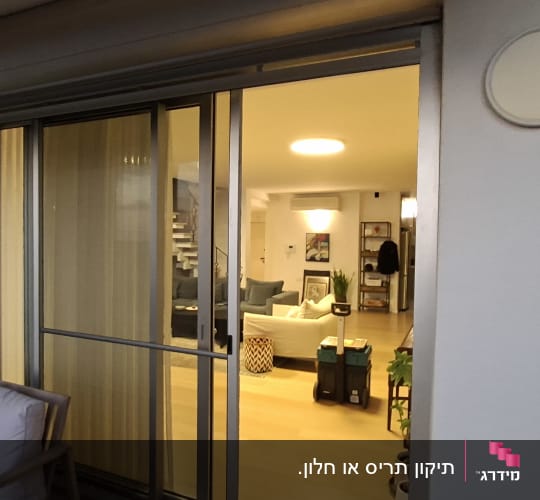 דלת הזזה מזכוכית עם וילון בסלון ביתי
